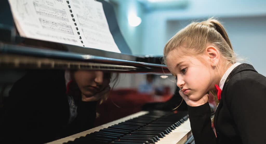 Young Girl Bored With Piano Music Practice