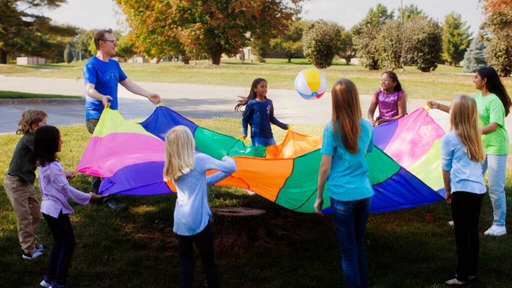 Students outside playing with parachute and ball