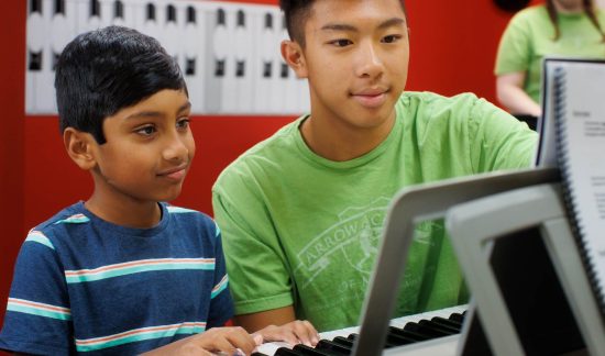 Young piano student with teacher